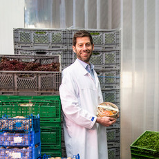 Ein Mann steht in einem Kühlhaus, umgeben von frischen Gemüse