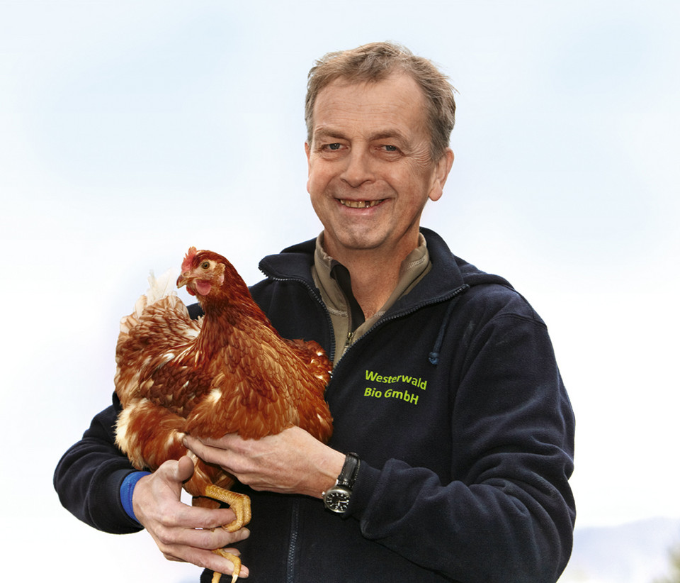 Herr Klein mit einem Huhn auf dem Arm
