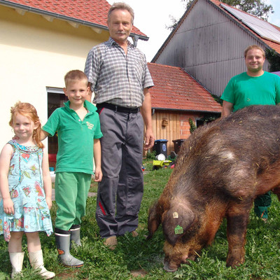 Landwirtfamilie mit großen brauen Schwein