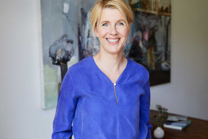 Blonde Frau mit blauer Bluse vor Bild