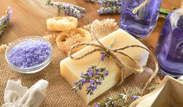 Feste Seife auf einem Tisch, der mit Lavendel und Ölen verziert ist