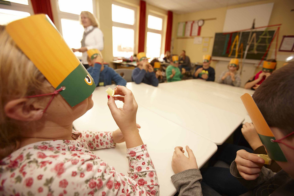 Kinder mit Masken probieren Zitrone