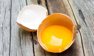 veganer Eiersatz ein aufgeschlagenes Ei auf Holzboden