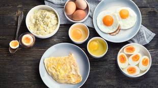 Verschieden zubereitete Eier in einer Schüssel oder auf einem Teller stehen auf einem Tisch