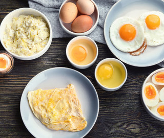 Verschieden zubereitete Eier in einer Schüssel oder auf einem Teller stehen auf einem Tisch