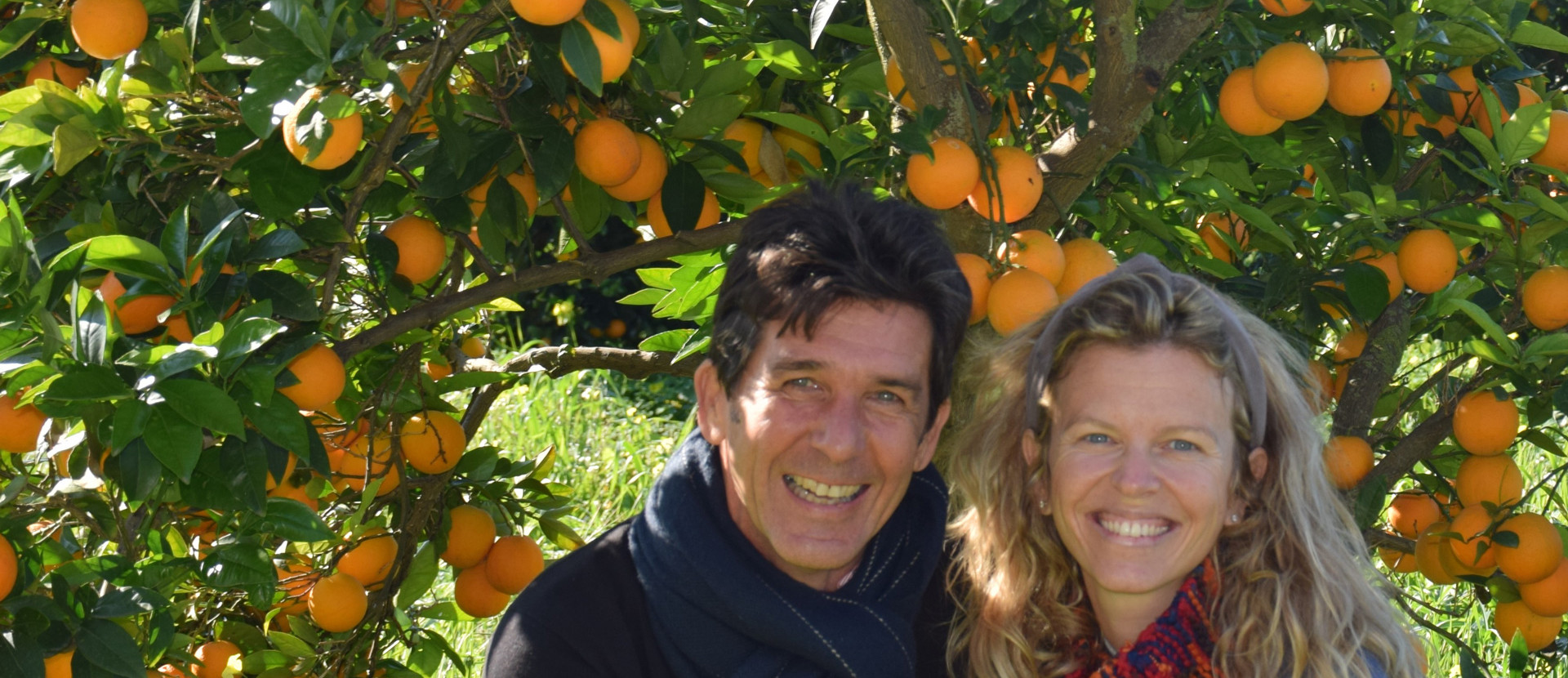 Eine Frau und ein Mann vor einem Orangenbaum