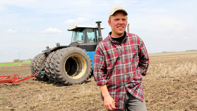 Das Bild zeigt einen Bauern auf dem Feld vor seinem Traktor. Wir bei tegut fördern den fairen Handel.