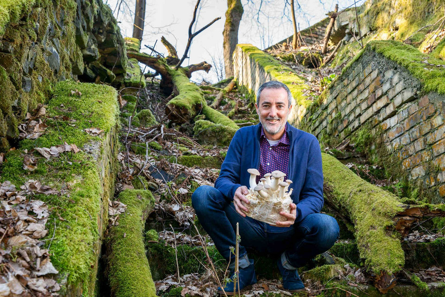 Mann im Wald mit Pilzen in der Hand