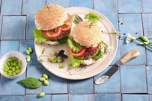 Das Bild zeigt zwei leckere vegane Burger mit Protein Patty, grünen Salatblättern und Tomatenscheiben.