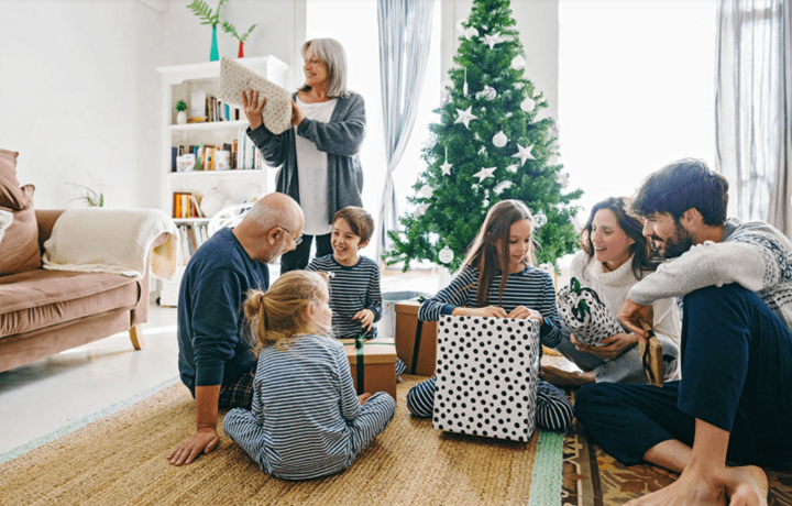 Familie an Weihnachten vor dem Weihnachtsbaum mit Geschenken