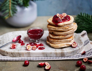 Vegane Pancakes mit Cranberry-Soße serviert auf weißer Marmorplatte