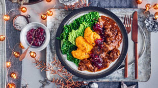 Wildgulasch mit Kürbis und Wirsing festlich angerichtet auf einem Teller