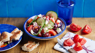 Griechischer Salat angerichtet auf einem blauen Teller
