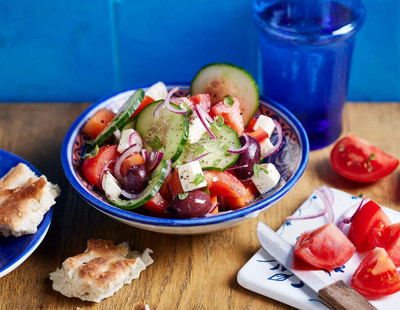 Griechischer Salat angerichtet auf einem blauen Teller