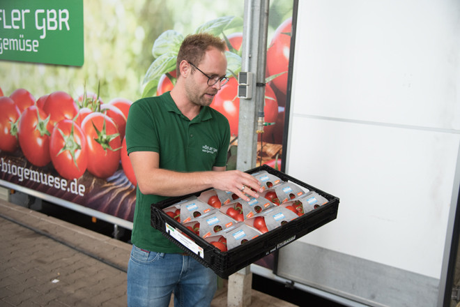 Patrick Höfler hält eine Kist mit Tomaten