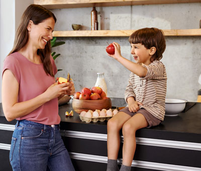 Regional und saisonal einkaufen: Mutter mit kleinem Jungen in der Küche.