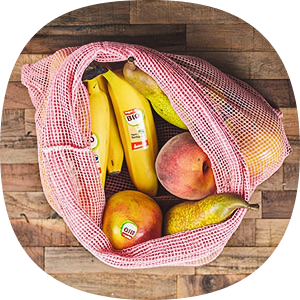 Bananen und Äpfel liegen in einem wieder verwendbaren Netz