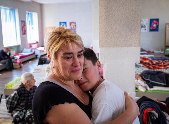Eine Mutter umarmt weinend ihren Sohn