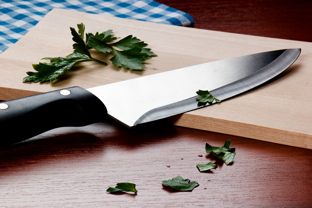 Messer auf Holzbrett mit Petersilie