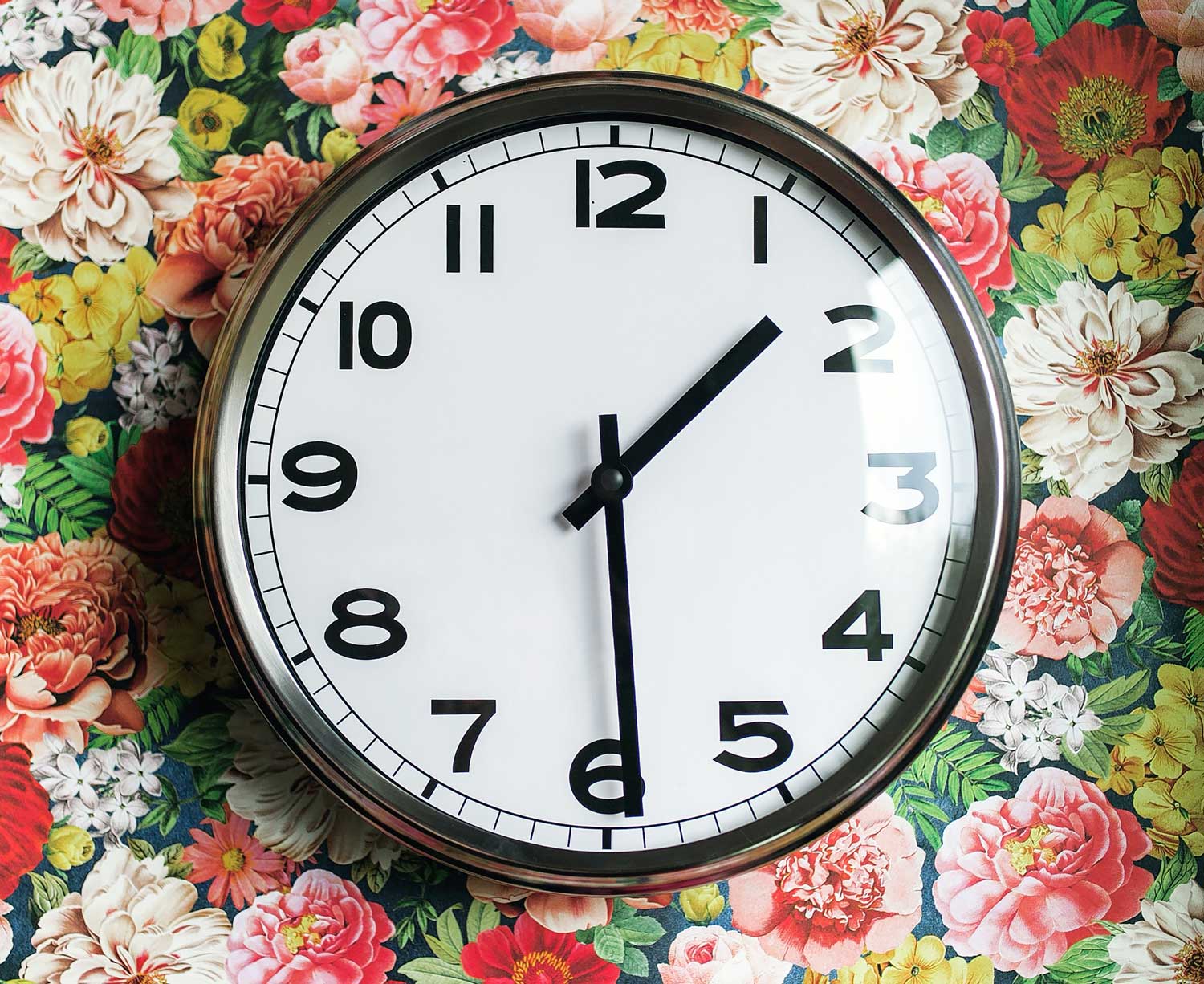 Uhr auf buntem Blumen-Hintergrund 
