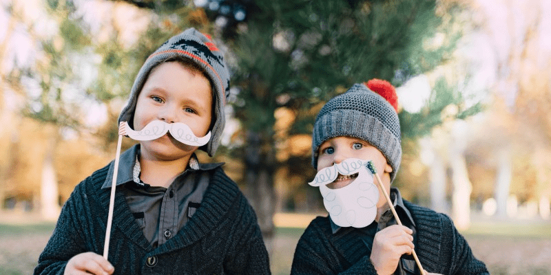 Zwei Jungs mit Wintermütze und Weihnachtsmann-Bart.