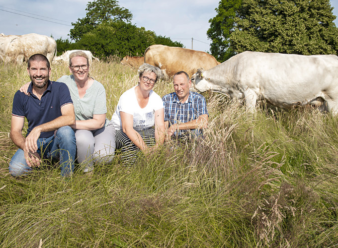Die Familie Prahl-Prignitz kniet auf dem Feld vor Ihren Uckermarkrindern