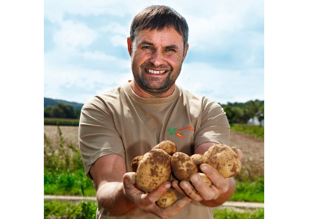 Bauer mit Hände voller Kartoffeln