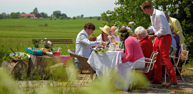 Menschen essen draußen an einem Tisch